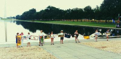 Washington, DC – several people holding multiple ribbon panels by the Capital’s reflecting pool.